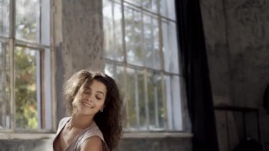 Uzun saçlı, modern dansçı kadın. Çağdaş serbest stil. Stüdyoda büyük camlı beyaz bir kız dans ediyor. Seksi kız dans hareketleri yapıyor..