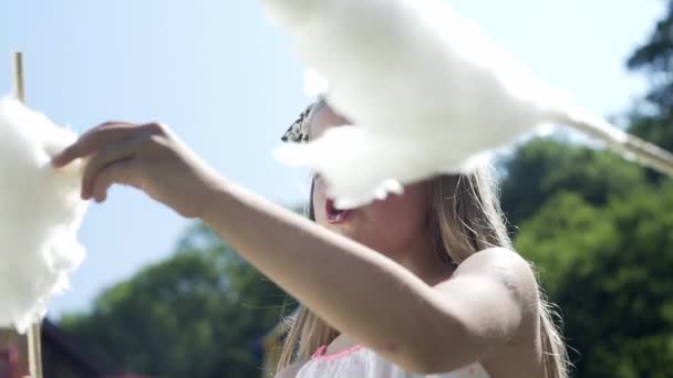 女の子は遊び場で綿菓子を食べる — ストック動画