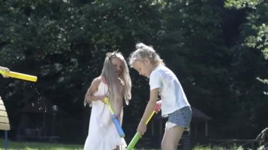 Çocuklar dışarıda farklı oyunlar oynuyor. Çocuklar dışarıda birlikte eğleniyorlar. Mutlu kızlar oyun alanında oynamayı sever. Çocuklar oyun parkına neşeyle su döker..