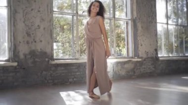 Uzun saçlı, modern dansçı kadın. Çağdaş serbest stil. Stüdyoda büyük camlı beyaz bir kız dans ediyor. Seksi kız dans hareketleri yapıyor..