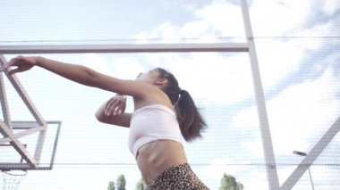 beautiful girl, gymnast, shows gymnastic tricks and fitness workout on the sports field / flattering girl, gymnast, performs sports exercises, stretching, sits and sits on the splits .