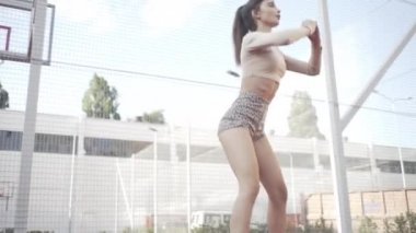 beautiful girl, gymnast, shows gymnastic tricks and fitness workout on the sports field / flattering girl, gymnast, performs sports exercises, stretching, sits and sits on the splits .