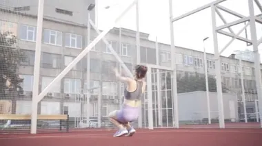 beautiful girl, gymnast, shows gymnastic tricks and fitness workout on the sports field / flattering girl, gymnast, performs sports exercises, stretching, sits and sits on the splits .