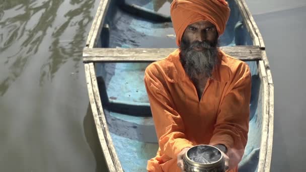 インドの僧侶は 聖なるカップを持つボートに乗って古い寺院に浮かび お香を注ぐ — ストック動画