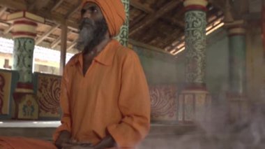 Eski bir tapınaktaki bir keşiş kutsal bir ateş yakar, rahibe ona Kutsal Kase 'yi, Hint tapınağı Maharaja' yı getirir.