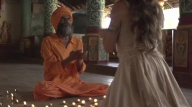 Eski bir tapınaktaki bir keşiş kutsal bir ateş yakar, rahibe ona Kutsal Kase 'yi, Hint tapınağı Maharaja' yı getirir.