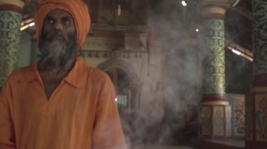 Eski bir tapınaktaki bir keşiş kutsal bir ateş yakar, rahibe ona Kutsal Kase 'yi, Hint tapınağı Maharaja' yı getirir.