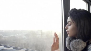 Pencerenin yanındaki seksi kız tatlı tatlı gülümsüyor, romantik, hayattan harika anlar hatırlıyor, kış havası..