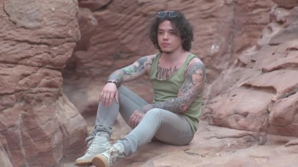 这家伙坐在峡谷里摆姿势拍照 撒哈拉沙漠 — 图库视频影像