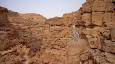 Kanyonda dans eden bir adam, şık bir şekilde hareket ediyor, seyahatler, sıcaklık, Sahara