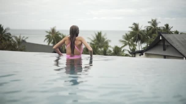 プールでのセクシーな女の子の水泳 リラックス 非常に美しい姿の水着で — ストック動画