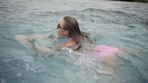 プールでのセクシーな女の子の水泳 リラックス 非常に美しい姿の水着で — ストック動画