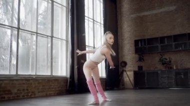 Çatı katındaki bir kız ritmik jimnastik egzersizleri yapıyor.