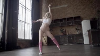 Çatı katındaki bir kız ritmik jimnastik egzersizleri yapıyor.