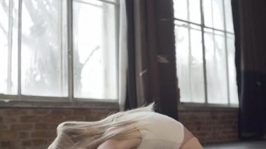 Çatı katındaki bir kız ritmik jimnastik egzersizleri yapıyor.