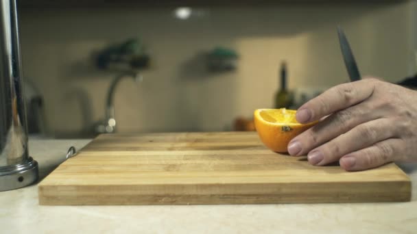 Hombre Corta Una Naranja Con Cuchillo Una Tabla — Vídeos de Stock