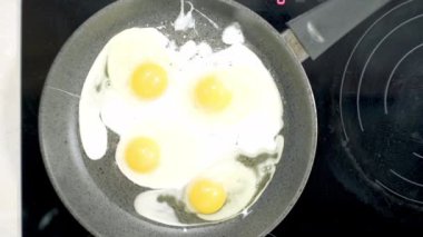Kızarmış yumurtalar evde tavada pişiriliyor. Ocakta, ayçiçeği yağında.