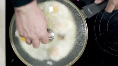 Kızarmış yumurtalar evde tavada pişiriliyor. Ocakta, ayçiçeği yağında.