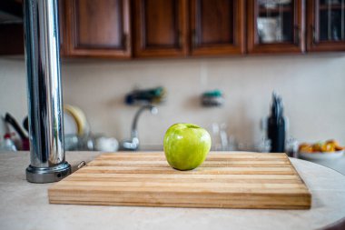Elma, mutfaktaki bir masanın üzerinde duruyor.
