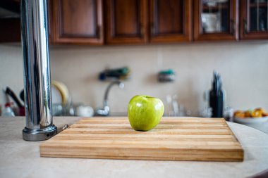 Elma, mutfaktaki bir masanın üzerinde duruyor.