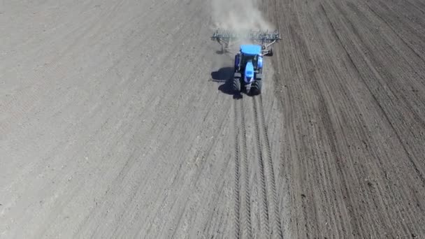 トラクターは畑を横切り 播種のために土地を耕し 春に穀物を再播種する準備をする — ストック動画