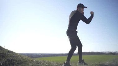 Bir adam tarlada, tarlada, adadaki bir adamda, bir gölgeyle mücadele ediyor.