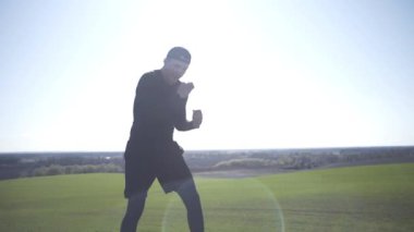 Bir adam tarlada, tarlada, adadaki bir adamda, bir gölgeyle mücadele ediyor.