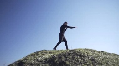 Bir adam tarlada, tarlada, adadaki bir adamda, bir gölgeyle mücadele ediyor.