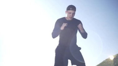 Bir adam tarlada, tarlada, adadaki bir adamda, bir gölgeyle mücadele ediyor.