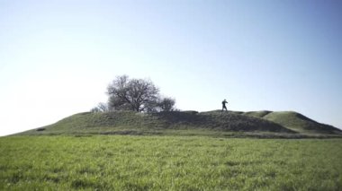 Bir adam tarlada, tarlada, adadaki bir adamda, bir gölgeyle mücadele ediyor.