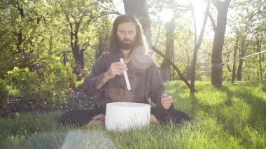 Bir qigong ustası gong ve kristal kase kullanarak meditasyon yapar, Kristal Tibet şarkı kasesi, bir usta vücut için enerji alır.