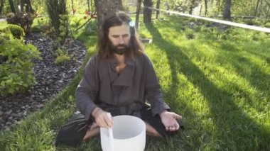 Bir qigong ustası gong ve kristal kase kullanarak meditasyon yapar, Kristal Tibet şarkı kasesi, bir usta vücut için enerji alır.