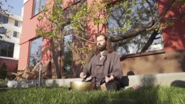 Bir qigong ustası gong ve kristal kase kullanarak meditasyon yapar, Kristal Tibet şarkı kasesi, bir usta vücut için enerji alır.
