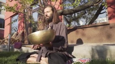 Bir qigong ustası gong ve kristal kase kullanarak meditasyon yapar, Kristal Tibet şarkı kasesi, bir usta vücut için enerji alır.