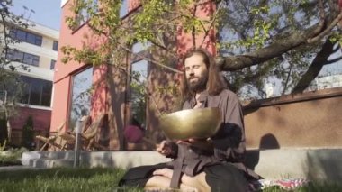 Bir qigong ustası gong ve kristal kase kullanarak meditasyon yapar, Kristal Tibet şarkı kasesi, bir usta vücut için enerji alır.