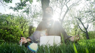 Bir qigong ustası gong ve kristal kase kullanarak meditasyon yapar, Kristal Tibet şarkı kasesi, bir usta vücut için enerji alır.