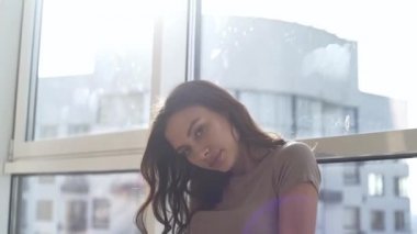 Günbatımında seksi bir manken panoramik pencerelerle evinde poz veriyor. Duygu dolu akşam havası sakin, şehir ve Dinyeper nehri dışında..