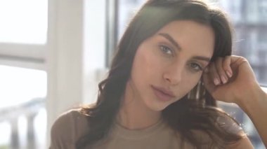Günbatımında seksi bir model panoramik pencereli dairesinde seksi bir model günbatımında panoramik pencereli bir şekilde poz veriyor. Duygu dolu akşam havası sakin, şehir ve Dinyeper nehri dışında..