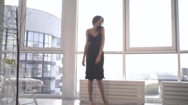 Günbatımında seksi bir manken panoramik pencerelerle evinde poz veriyor. Duygu dolu akşam havası sakin, şehir ve Dinyeper nehri dışında..