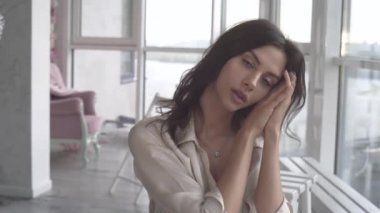 Günbatımında seksi bir manken panoramik pencerelerle evinde poz veriyor. Duygu dolu akşam havası sakin, şehir ve Dinyeper nehri dışında..