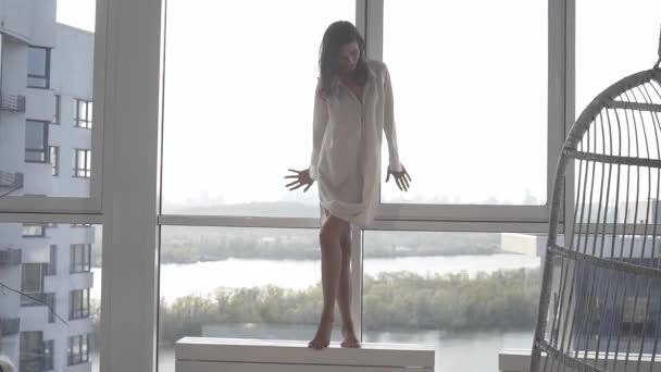 一个性感的模特在日落时在她的公寓里摆姿势 她的房间有全景窗户 情绪消沉 夜晚平静 城外与第聂伯河 — 图库视频影像