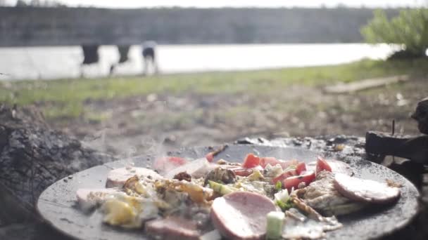 湖边钓鱼的面包师 在火上准备土豆和鸡肉 野外条件 住在森林里 在火上吃 住在大自然里 — 图库视频影像