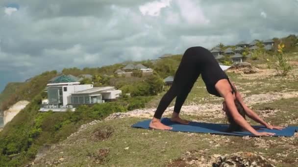 Женщина в позе йоги "Обратная сторона собаки" — стоковое видео