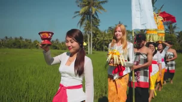 Balinese processie gaan door rijstvelden met aanbod — Stockvideo