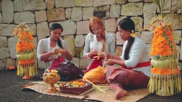 Balinesinnen zeigen Touristen, wie man Opfer bringt — Stockvideo