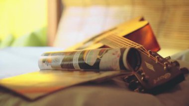 Gitar ve bir yatakta dergi kapat