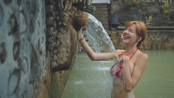 Young woman under stream of water in hot springs — Stock Video