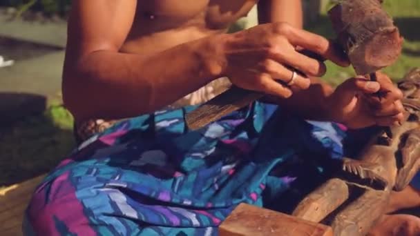 Balinese man carving een houten beeldje — Stockvideo