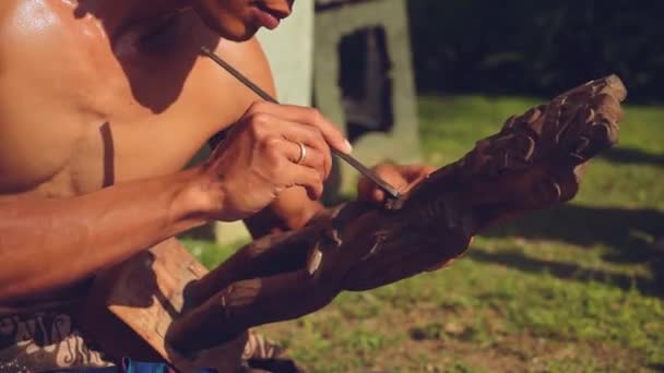 Hombre balinés tallando una estatuilla de madera — Vídeo de stock