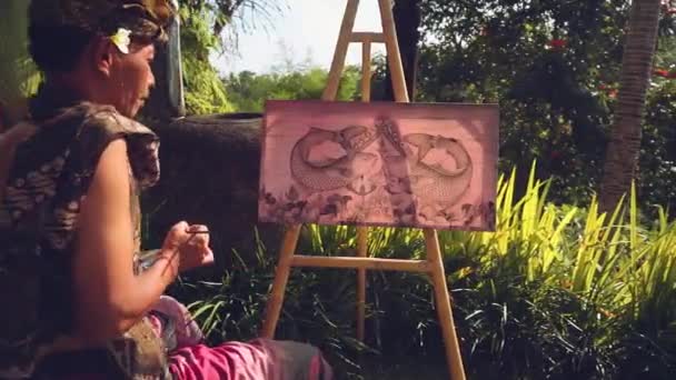 Balinese kunstenaar schilderij in traditionele kleding — Stockvideo